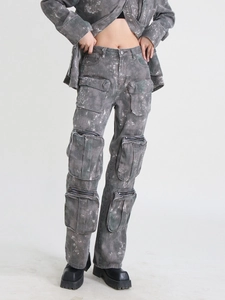 Détail de jean cargo délavé à taille haute avec de multiples poches zippées en métal et look rétro