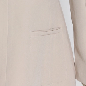 Detailed view of the sleek waist pocket and smooth fabric texture on this blazer