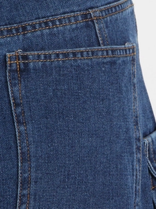 Primer plano de jeans de mezclilla azul oscuro con costuras en contraste y bolsillos