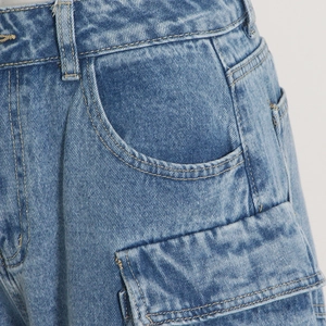Detail of blue denim cargo pants showing waistband, side pockets and flap pocket