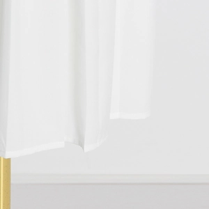 Detailed view of white pleated skirt hem with smooth stitching on a golden hanger