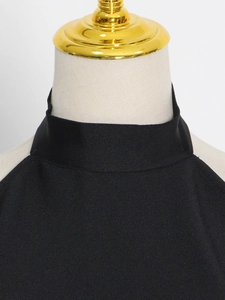 Detail of black halter neckline showing fine ribbed texture and premium woven fabric