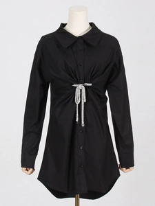 Détail de la robe chemise noire avec boucle papillon en strass et plis à la taille