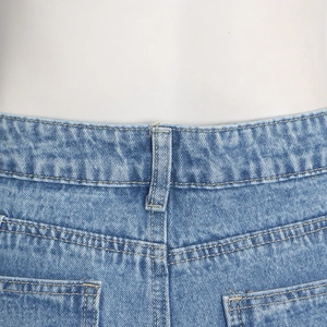Close-up of light blue denim jeans showing yellow stitching and fabric texture
