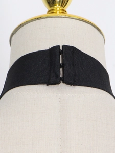 Detail of the black elastic halter neck strap with three-row metal hook and eye closures