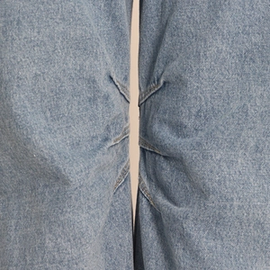 Detailed macro shot of light blue washed denim fabric seams and cotton twill texture