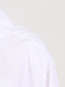 Gros plan détaillé montrant les coutures précises de l'épaule sur une chemise blanche