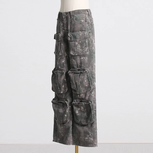 Détail du pantalon cargo gris avec de multiples poches 3D et une finition denim délavé