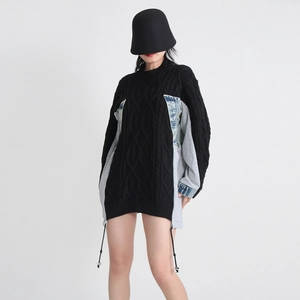 Detail showing denim patchwork on oversized black cable knit sweater for women