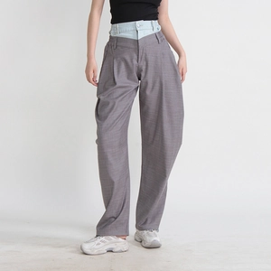 Détail du pantalon large gris avec taille haute double et empiècement en denim contrasté