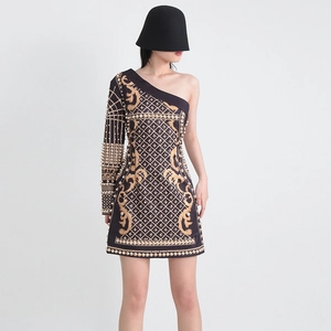 Détails de l'imprimé baroque doré et perles sur une robe noire à épaule dénudée