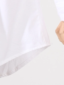 Gros plan détaillé de la robe chemise blanche avec ourlet incurvé et double couture précise