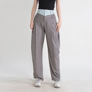 Détail du pantalon gris large avec une taille double en jean et des plis sur le devant