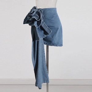 Détail de la mini-jupe en jean avec rose 3D et longs rubans asymétriques fluides