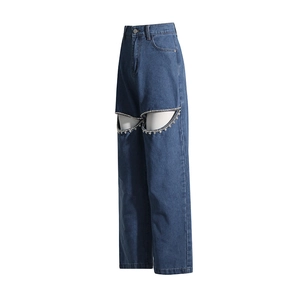 Dettaglio jeans blu a vita alta con ritagli e finiture in strass a forma di cuore