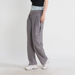 Détail du pantalon à carreaux gris avec un design unique de patchwork en jean à la taille