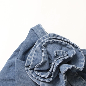 Gros plan détaillé du tissu denim bleu texturé avec sergé visible et aspect délavé