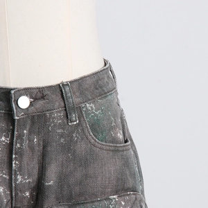 Détail du jean gris délavé à taille haute avec éclaboussures de peinture et bouton