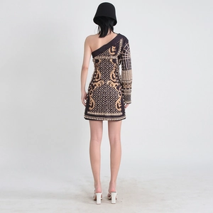 Détail de la broderie baroque dorée et du perlage artisanal sur la robe noire chic