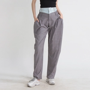 Détail d'un pantalon large à carreaux gris avec taille double en denim superposée chic