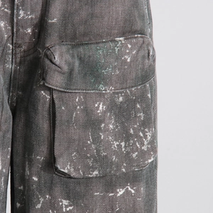 Gros plan détaillé sur une poche cargo grise avec éclaboussures de peinture sur denim