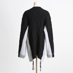 Close-up of cable knit back with denim patchwork cuffs and metallic buckle details