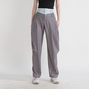 Détail d'un pantalon taille haute avec double taille et patchwork de denim contrasté
