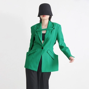 Détail du blazer vert avec découpes chics à la taille et design à lacets sur le devant