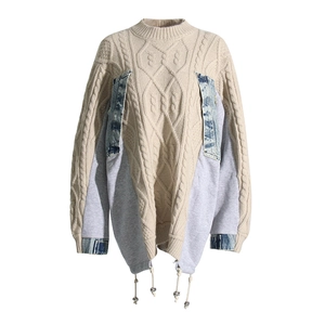 Detail of deconstructed cable knit sweater with denim patchwork and drawstring hem