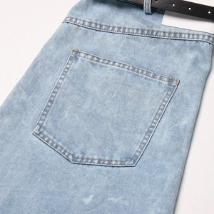Detalle de vaqueros azul claro lavado con parche de cuero blanco y costuras de contraste