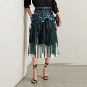 Detail of high waist denim skirt with green mesh patchwork and neon fringe trim