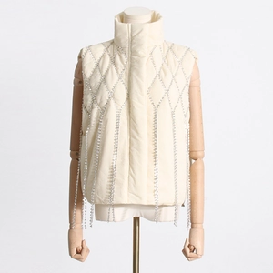 Detail of cream puff vest featuring diamond quilted patterns and sparkling rhinestone fringe