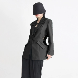 Détail d'un tailleur noir pour femme avec découpes à la taille et sangle de col