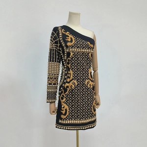 Détail de broderie baroque et perles posées à la main sur une robe noire asymétrique