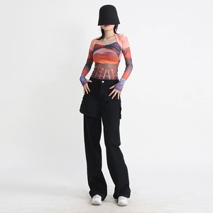 Dettaglio dei pantaloni neri a gamba larga con design a strati stile gonna unica