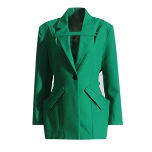 Gros plan détaillé du blazer vert émeraude avec revers en pointe et sangle à la taille