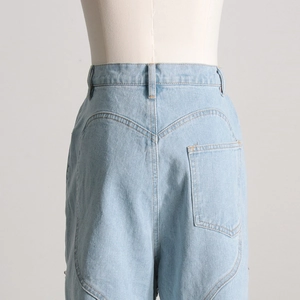 Dettaglio di jeans a vita alta celeste con ricamo a forma di cuore sulla tasca posteriore