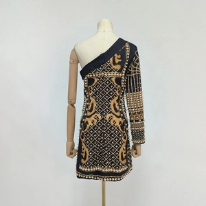 Détail de la robe noire asymétrique baroque avec broderies d'or et perles de nacre