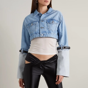 Detail of denim jacket sleeve with adjustable black leather straps and long cuffs