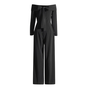 Combinaison noire chic à épaules dénudées avec un grand nœud et une coupe jambe large