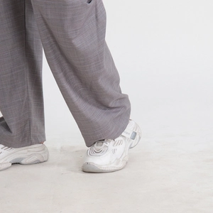 Gros plan sur un pantalon gris à carreaux avec des baskets rétro à semelles épaisses