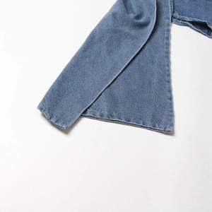 Vue détaillée de la texture denim délavé et de l'ourlet d'une jupe bleue en A