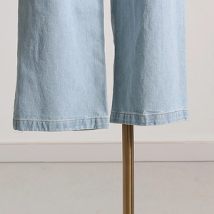 Dettaglio dell'orlo a doppia cucitura dei jeans azzurri a gamba larga in denim lavato