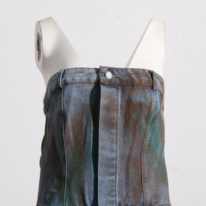 Détail d'un haut bustier en jean camouflage vintage avec boutons métalliques et effet tie-dye