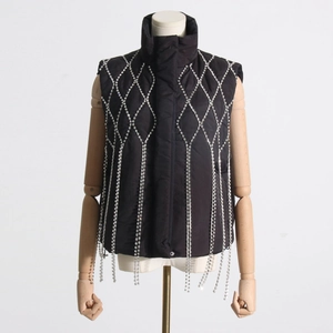 Detail of black stand-up collar vest featuring sparkling diamond mesh and silver tassels