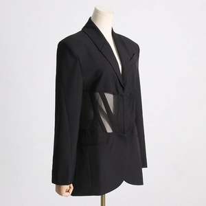 Detailed view of the sheer mesh corset waist with boning on this black blazer