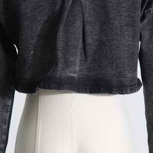 Λεπτομερής προβολή του γκρι τζιν cropped top με ξεβαμμένη υφή και vintage εμφάνιση