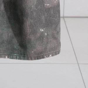 Gros plan détaillé du denim gris foncé délavé avec taches de peinture et coutures