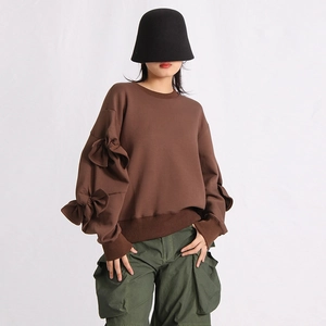Detail of dark brown sweatshirt featuring decorative bows on sleeves and ribbed cuffs