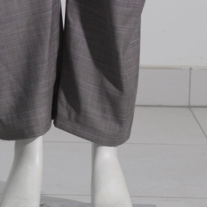 Gros plan détaillé du pantalon taupe à micro-carreaux avec ourlet lisse et tissu fluide